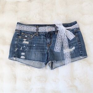Blue denim shorts with frayed details and a distressed look